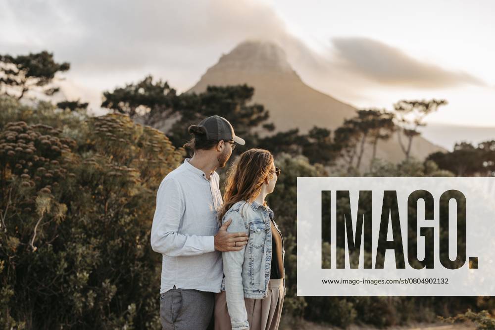 Paar steht bei Sonnenuntergang vor dem Signal Hill, Kapstadt, Südafrika Couple standing in front of Signal Hill at sunset, Cape Town, South Africa, Africa