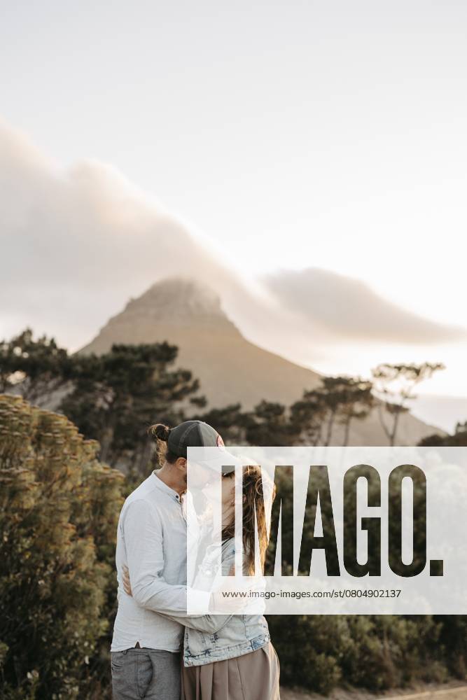Paar steht bei Sonnenuntergang vor dem Signal Hill, Kapstadt, Südafrika Couple standing in front of Signal Hill at sunset, Cape Town, South Africa, Africa