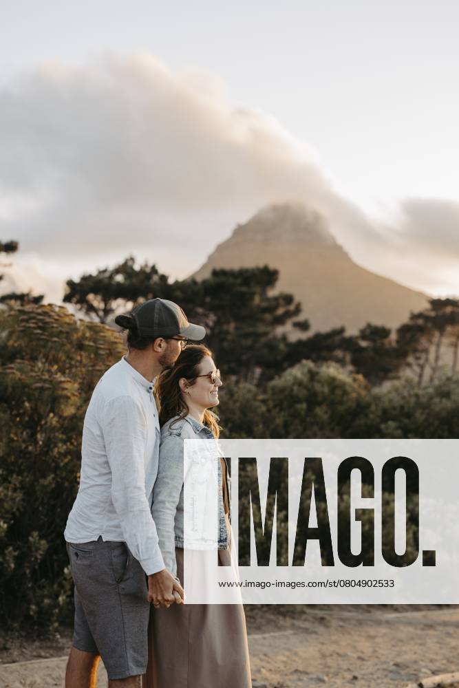 Paar steht bei Sonnenuntergang vor dem Signal Hill, Kapstadt, Südafrika Couple standing in front of Signal Hill at sunset, Cape Town, South Africa, Africa