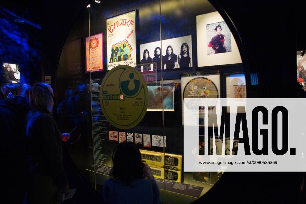 London, London, United Kingdom - People are seen looking at some Pink Floyds artwork..The Pink Floyd exhibition was held in London at Victoria and Albert Museum from 13 May 2017 to 15 October 2017. Visitors experienced a remarkable and unparalleled audio-visual journey from the beginning of the progressive music band until the present day by seeing their encounter costumes, music instruments, posters, artworks, sculptures, while watching videos and listening their music. Pink Floyd is an English progressive and psychedelic music band formed in London in 1965. London United Kingdom - ZUMAs197 20171015_zab_s197_016