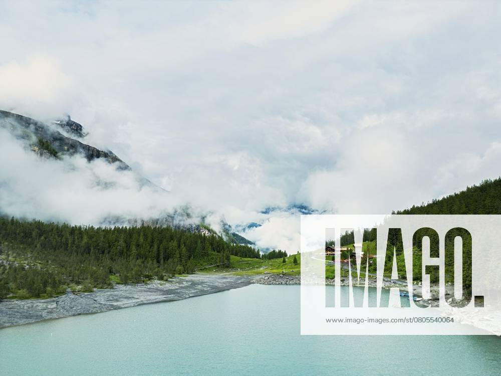 Ein ruhiger See umgeben von üppigen Wäldern und nebligen Bergen unter einem bewölkten Himmel, Natur, Wasser, Eis, Gletscherströme, Bergsee, See, Oeschinensee, Oeschinensee oberhalb von Kandersteg, Schweizer Alpen, Schweiz, Europa A serene lake surrounded by lush forests and misty mountains under a cloudy sky, nature, water, ice, glacial streams, mountain lake, lake, Oeschinensee, Lake Oeschinen above Kandersteg, Swiss Alps, Switzerland, Europe
