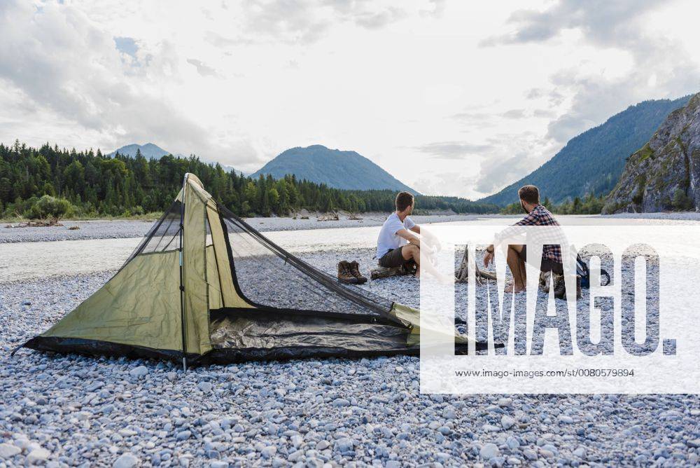 Germany, Bavaria, two hikers camping on gravel bank looking at view model released Symbolfoto DIGF02829