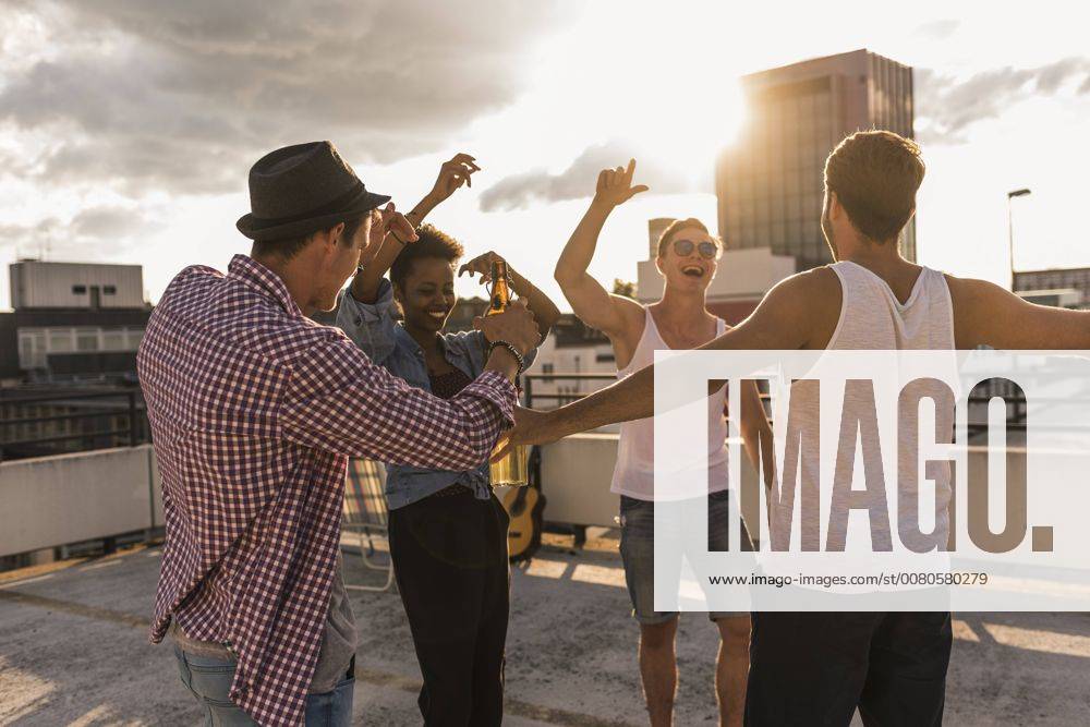 Friends having a rooftop party model released Symbolfoto UUF11480