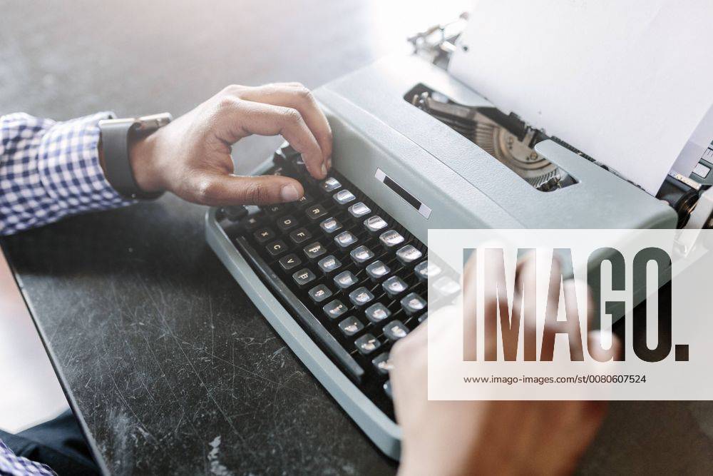 Close-up of man at desk using typewriter model released Symbolfoto GIOF03137