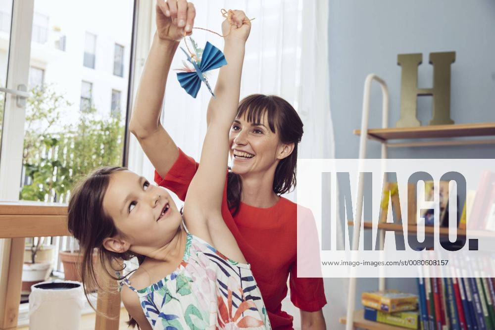 Mother and daughter playing with self-made paper bird model released Symbolfoto property released MFF03805