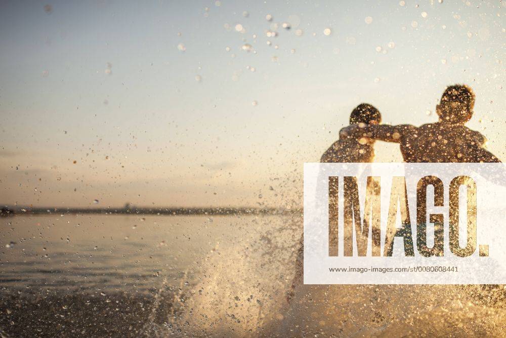 Two friends running in water model released Symbolfoto VPIF00015