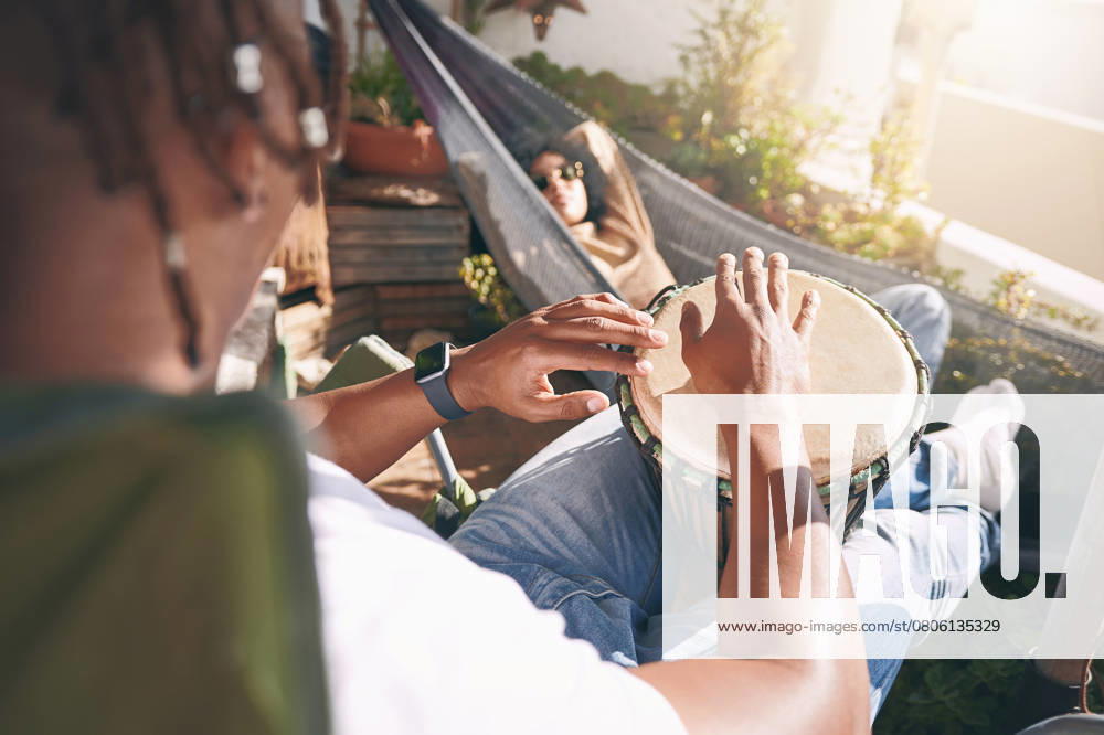 Friends, relax and playing drums for fun, outdoor balcony and musician practice with instrument. Bongo, music hobby and chilling together on weekend for peace, people and hammock for artistic bonding. model released property released