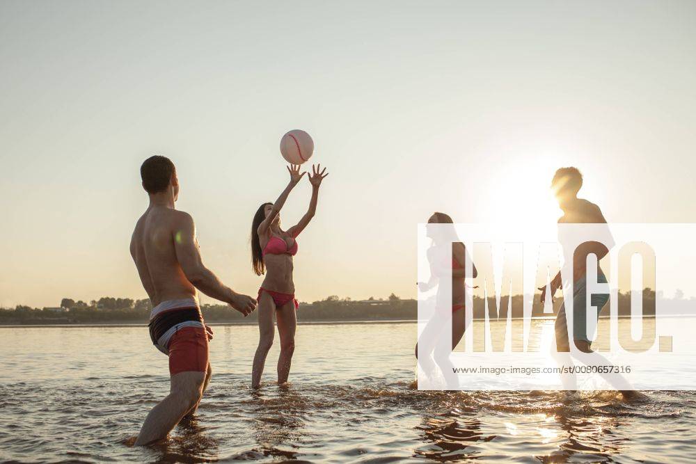 Happy friends playing with a ball in water model released Symbolfoto VPIF00013