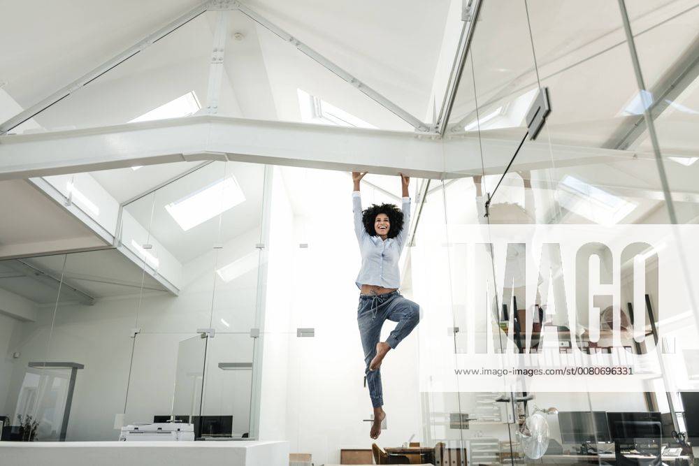 Young woman hanging on beam in office model released Symbolfoto property released KNSF02350