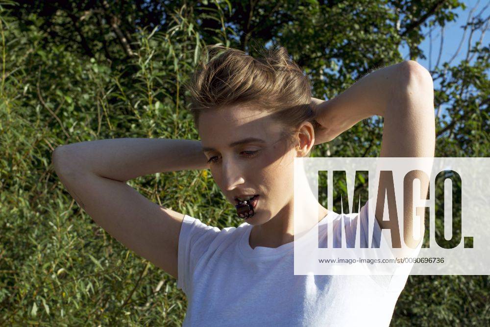Young woman pinning up her hair model released Symbolfoto LMF00765