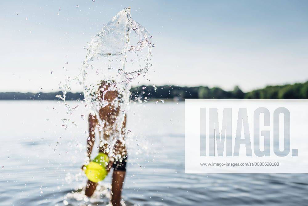 Boy splashing with water at lakeshore close up model released Symbolfoto MJF02180