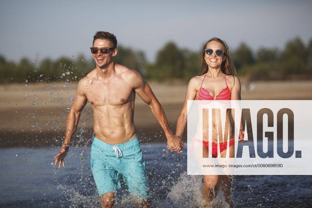 Happy couple splashing in water model released Symbolfoto VPIF00004