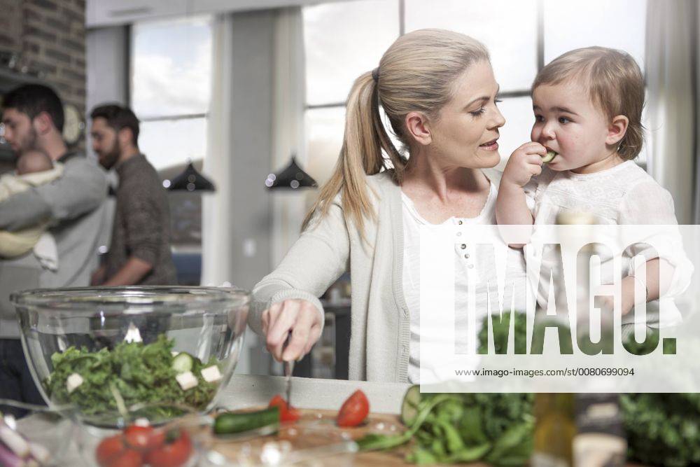 Mother holding baby preparing a healthy meal in kitchen model released Symbolfoto property released ZEF14431