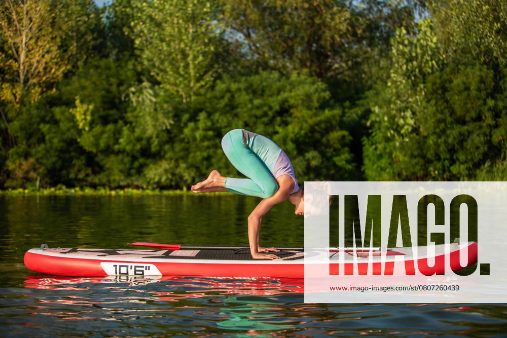 Young woman are doing yoga on a stand up paddle board SUP on a beautiful lake or river. The concept of a healthy lifestyle. Sport. Yoga. Hobby, model released, , 53657850.jpg, background, family, woman, beach, dog, water, silhouette, child, person, girl, sport, fitness, summer, nature, sun, yoga, paddle, holiday, relax, sea, sunset, sup, surfing, fun, lake, leisure, meditation, surfboard, air pump, balanced, bathing, blonde, boat, breathing technique, cobra, dying swan, fin, hobby, horizon, orange, pilates, pump up, rowing, stand up paddle, sun salutation, warrior, red, leggings, top RECORD DATE NOT STATED