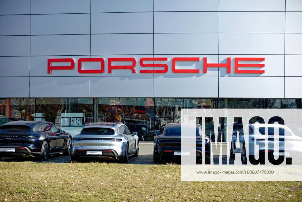 Logo the Car brand Porsche to the Facade of Porsche Center in Nuremberg with before that parked Vehicles 1104401528