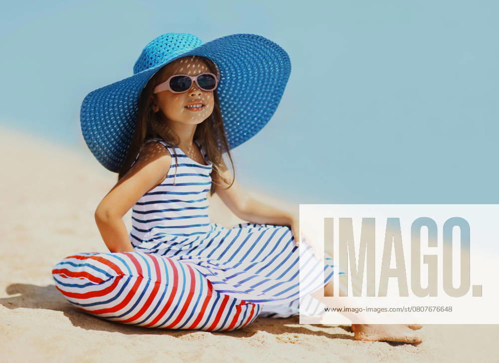 Summer holidays, vacation - beautiful little girl child wearing a straw hat, striped dress relaxing on beach near sea Summer holidays, vacation - beautiful little girl child wearing a straw hat, striped dress relaxing on beach near sea ,model released, Symbolfoto