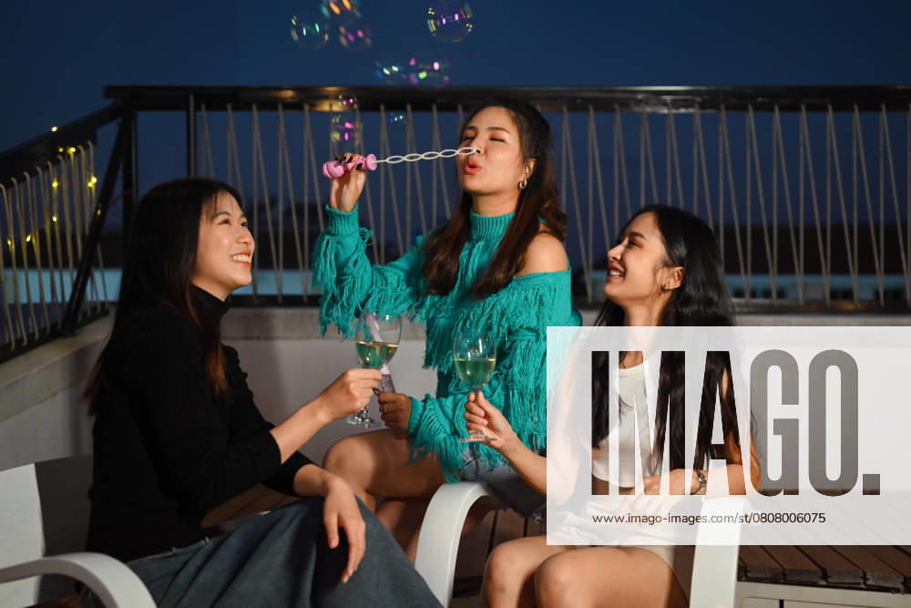 Young friends gathered together having fun toasting champagne and blowing soap bubbles at the rooftop night party, model released, , 57054790.jpg, rooftop, friendship, celebrating, person, sunset, alcohol, terrace, evening, outdoors, lifestyles, group, friends, celebration, smiling, drink, happiness, togetherness, enjoyment, joy, carefree, male, young adult, weekend, laughing, bar, balcony, cheer, talking, night, urban, relaxation, pub, roof, sky, enjoying, beverage, restaurant, entertainment, event, festival, adolescence, festive, chatting, having fun, joyful, union, friday, nightlife, nightclub, adult RECORD DATE NOT STATED