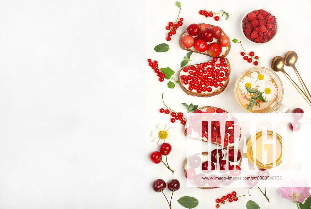 Gesundes Frühstück mit Zutaten und Kräutertee mit Kamille. Diät Obst Mini-Sandwiches mit weichem Hüttenkäse und frischen Beeren, Himbeeren, Johannisbeeren und Kirschen, Das Konzept der gesunden und natürlichen Lebensmitteln, Lebensstil, flach legen, Platz Healthy breakfast with ingredients and herbal tea with chamomile. Diet fruit mini sandwiches with soft cottage cheese and fresh berries, raspberries, currants and cherries, The concept of healthy and natural food, lifestyle, flat lay, space for text, selective focus
