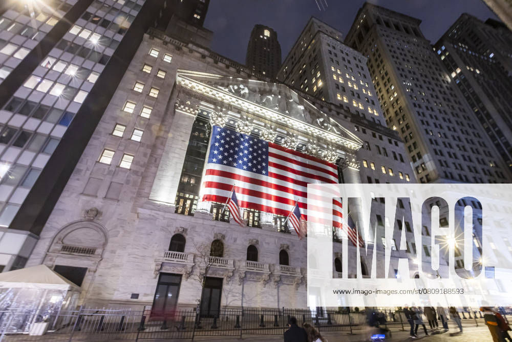 New York Stock Exchange NYSE Building In The Night Night view of the illuminated exterior of New York Stock Exchange with a big American flag from the front facade. NYSE building has the style of classical architecture of Greece with columns, the inscription New York Stock Exchange and US flags hanging. The financial organization at Wall Street is a symbol for the global and American Economy as one of the most powerful financial institution located in Wall Street at lower Manhattan in New York City, United States of America. The US stock market is reacting with heavy losses after president Trump tariffs announcement on April 2025. November 2024 in NYC, USA New York City Netherlands