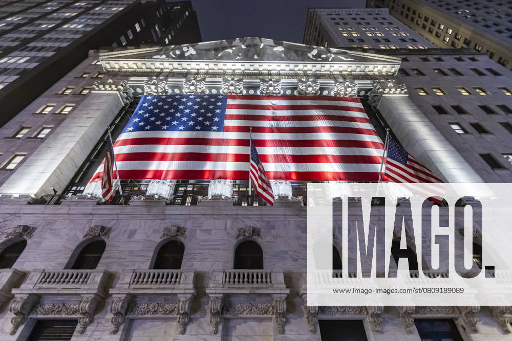 New York Stock Exchange NYSE Building In The Night Night view of the illuminated exterior of New York Stock Exchange with a big American flag from the front facade. NYSE building has the style of classical architecture of Greece with columns, the inscription New York Stock Exchange and US flags hanging. The financial organization at Wall Street is a symbol for the global and American Economy as one of the most powerful financial institution located in Wall Street at lower Manhattan in New York City, United States of America. The US stock market is reacting with heavy losses after president Trump tariffs announcement on April 2025. November 2024 in NYC, USA New York City Netherlands