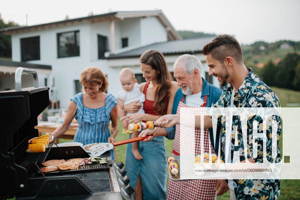 Three generations of family preparing food for a spring weekend barbecue. Three generations of family preparing food for a spring weekend barbecue. Garden party. model released