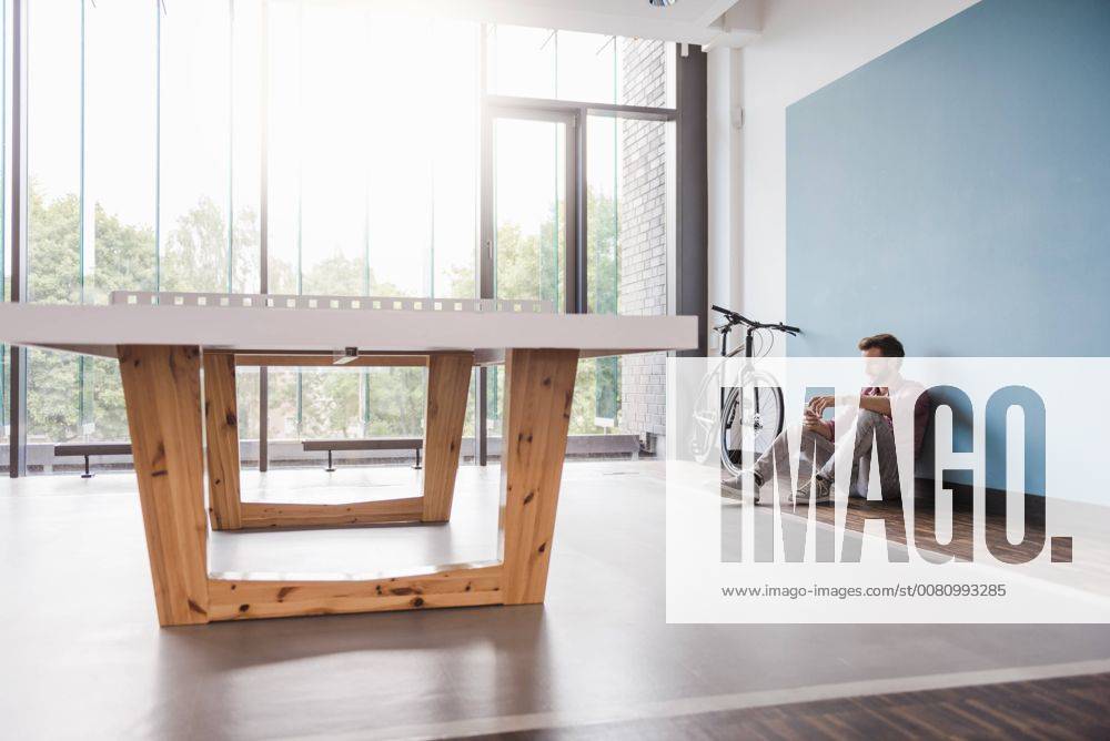 Man sitting on the floor in break room of modern office model released Symbolfoto property released DIGF02759