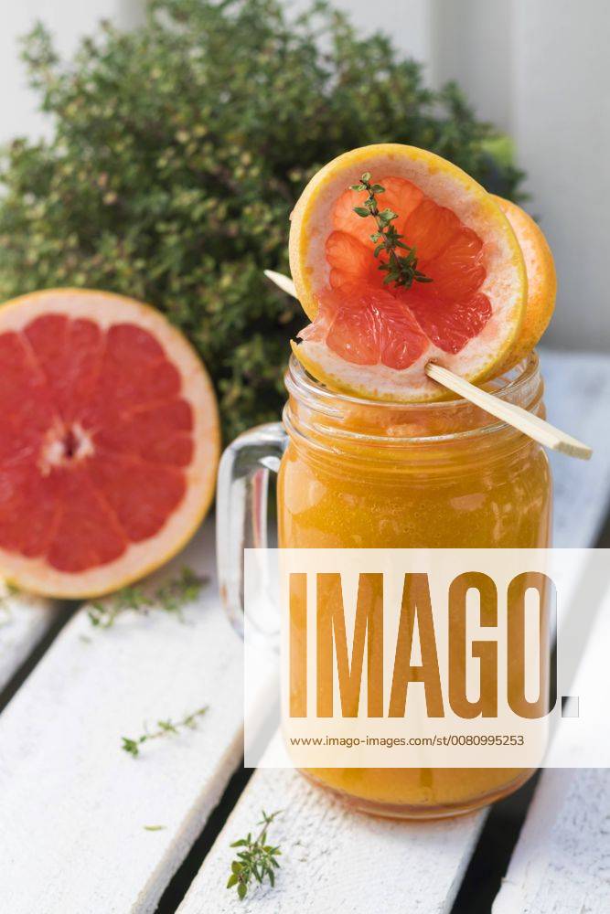 Glass of fruit smoothie with Pink Grapefruit, orange, mango and thyme YFF00678