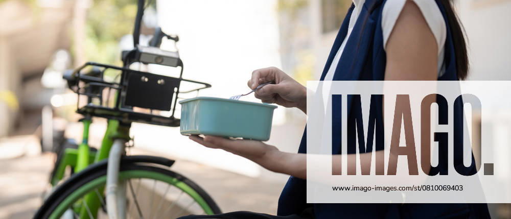 Young businesswoman while eating a lunch box sitting on a staircase during a break from work, concept healthy food using a bicycle for driving, Eco friendly vehicle, sustainable lifestyle concept., model released, , 58084352.jpg, business, lunch, box, break, healthy, bicycle, eco, friendly, vehicle, sustainable, lifestyle, businesswoman, employee, entrepreneur, woman, office, work, eating, female, shotlisteco, meal, eat, corporate, laptop, snack, computer, online, sitting, young, container, happy, professional, sustainableclimatevisuals, manager, person, company, vegetarian, workplace, adult, busy, job, nourishment, suit, vegetable, worker, indoors, outside, service, success, working RECORD DATE NOT STATED