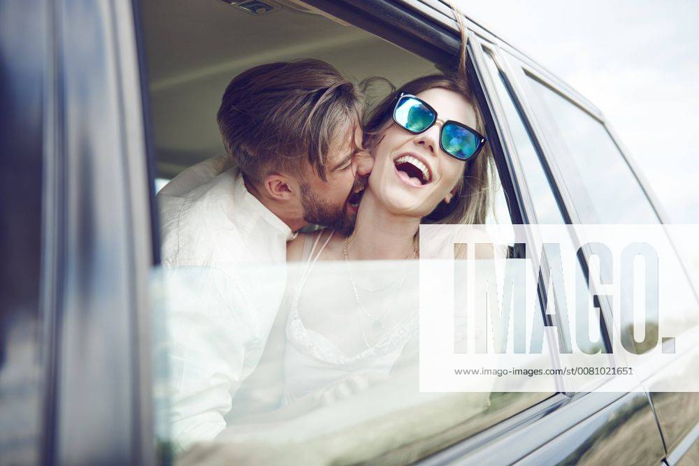 Playful affectionate young couple in car model released Symbolfoto ABIF00011