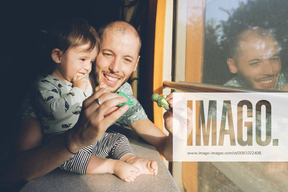 Father playing with his baby girl while traveling by train model released Symbolfoto GEMF01814
