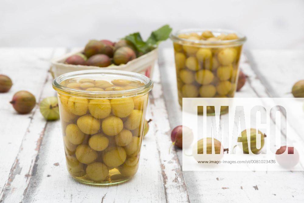 Jar of preserved gooseberries and gooseberries on wood LVF06293