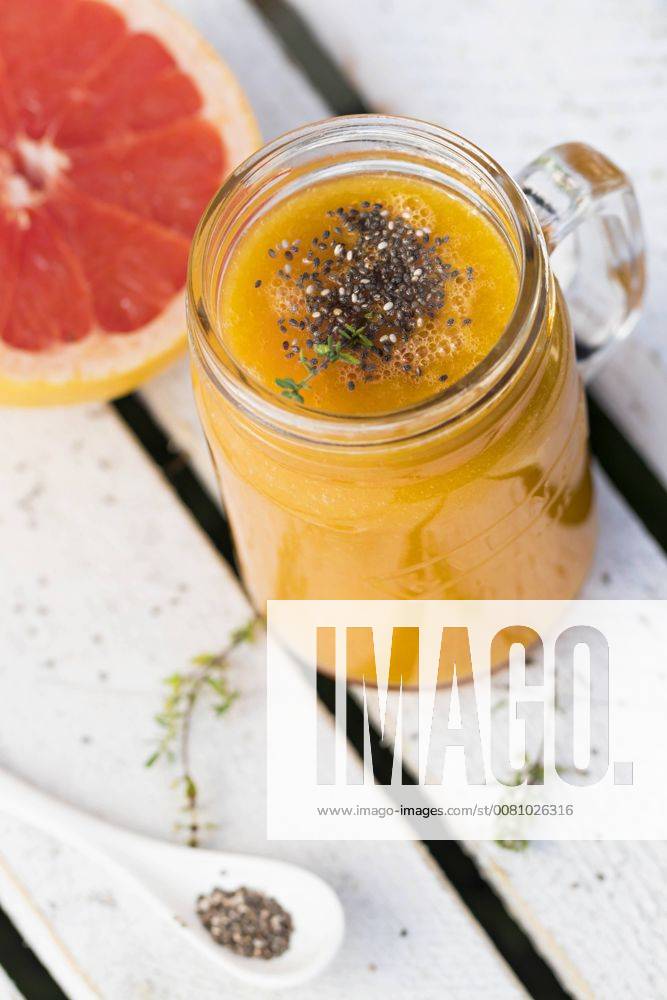 Glass of fruit smoothie with Pink Grapefruit, orange, mango, thyme and chia seeds YFF00679