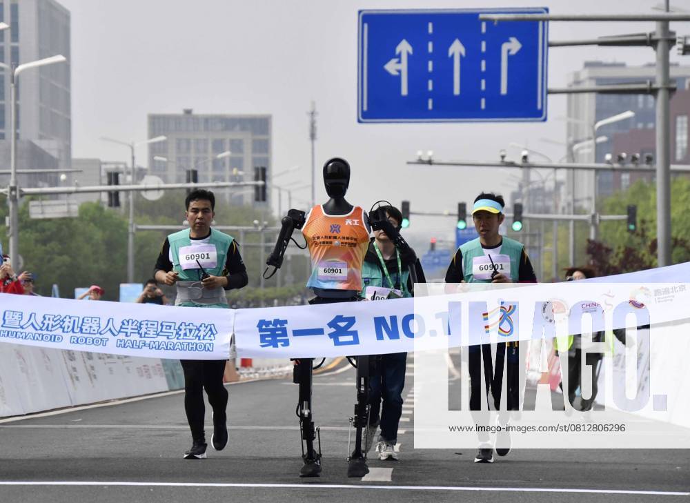 China, Roboter nehmen am Peking E Town Halbmarathon teil (250419) -- BEIJING, April 19, 2025 -- Robotic participant Tiangong Ultra (C) competes as engineers run alongside during the Beijing E-Town half-marathon and humanoid robots half-marathon in the Beijing Economic-Technological Development Area in southeast Beijing, China, April 19, 2025. ) (SP)CHINA-BEIJING-E-TOWN HALF MARATHON AND HUMANOID ROBOTS HALF MARATHON (CN) LixXin