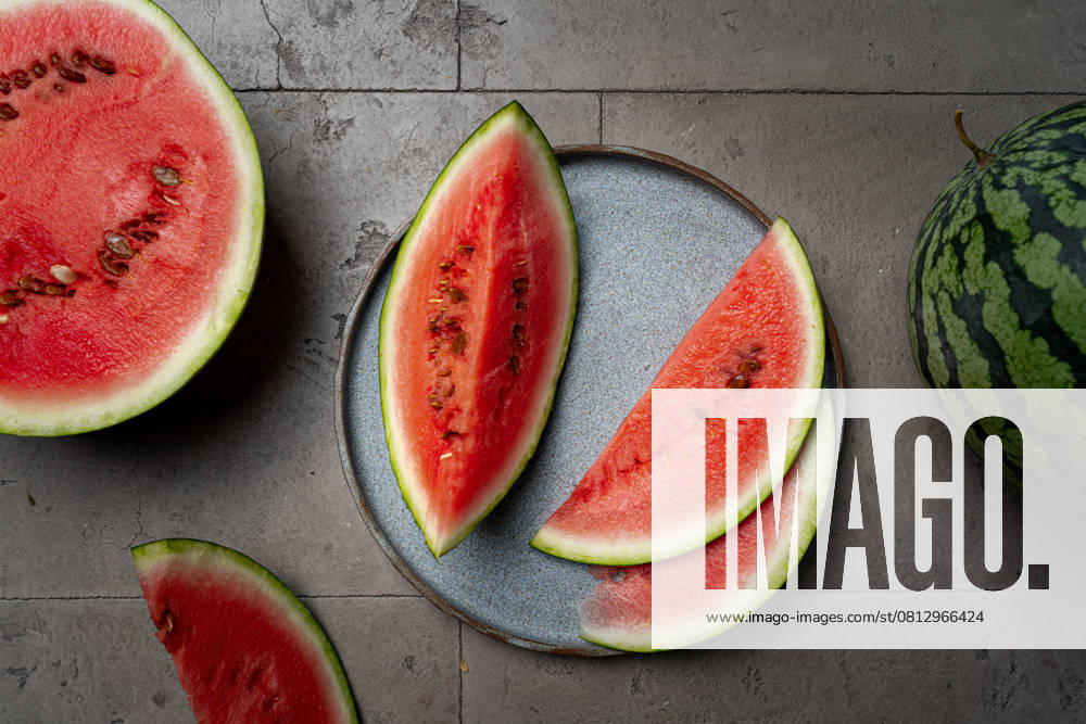 Frische Bio-Wassermelone Fresh organic watermelon with a slices on gray background, top view (License=RF)