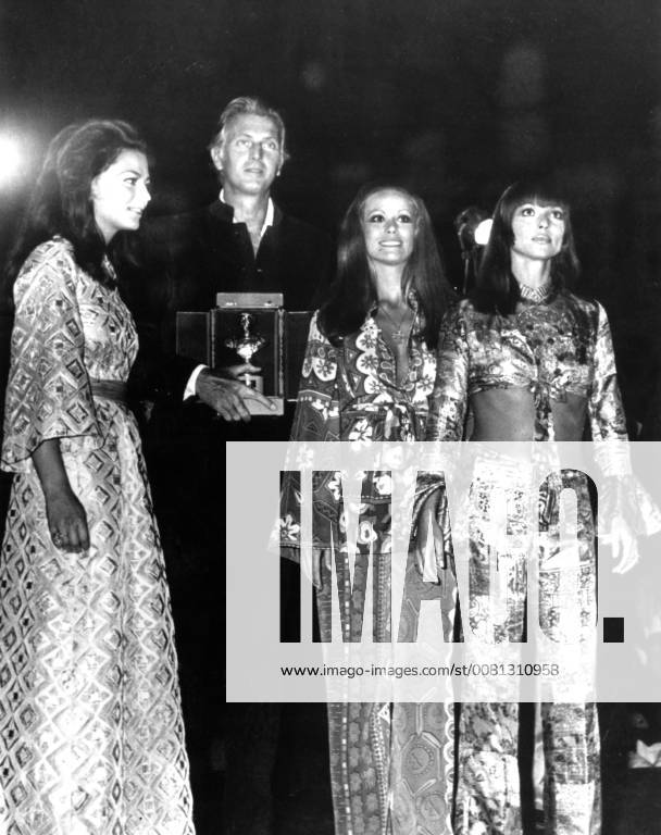 French designer Hubert de Givenchy pictured with actresses (left to right) Princess Ira Furstenberg , France s Claudine Auger and Italy s Elsa Martinelli , after he had been presented with the Golden Tiberius award as the best deisgner at the Maremoda Sea Fashion Show on the Isle of Capri , 12 September . Many famous stars and members of the European jet set attended the show . 14 September 1969, Italy