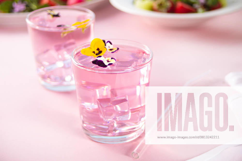 Gläser von rosa violett lila Cocktail dekoriert Blumen Viola pancies Glasses of pink violet purple cocktail decorated flowers viola pansy. Copy space. (License=RF)