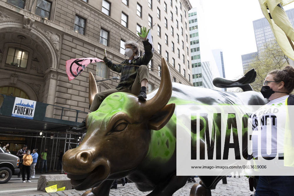 On Earth Day climate activists with Extinction Rebellion NYC write GREED and the Extinction Rebellion symbol in green on Wall Street s Charging Bull with removable chalk, hold XR flags and wear shirts that read NO 12839$ ON A DEAD PLANET. Demonstrators call for Wall Street banks to stop funding and profiting from fossil fuels that are destroying the planet. New York USA - ZUMAr174 20250422_znp_r174_006