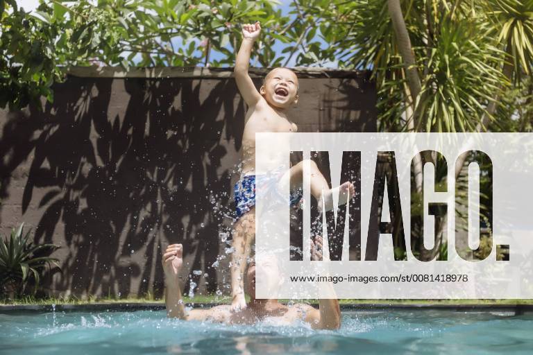 Father and son having fun in swimming pool model released Symbolfoto property released KNTF00932