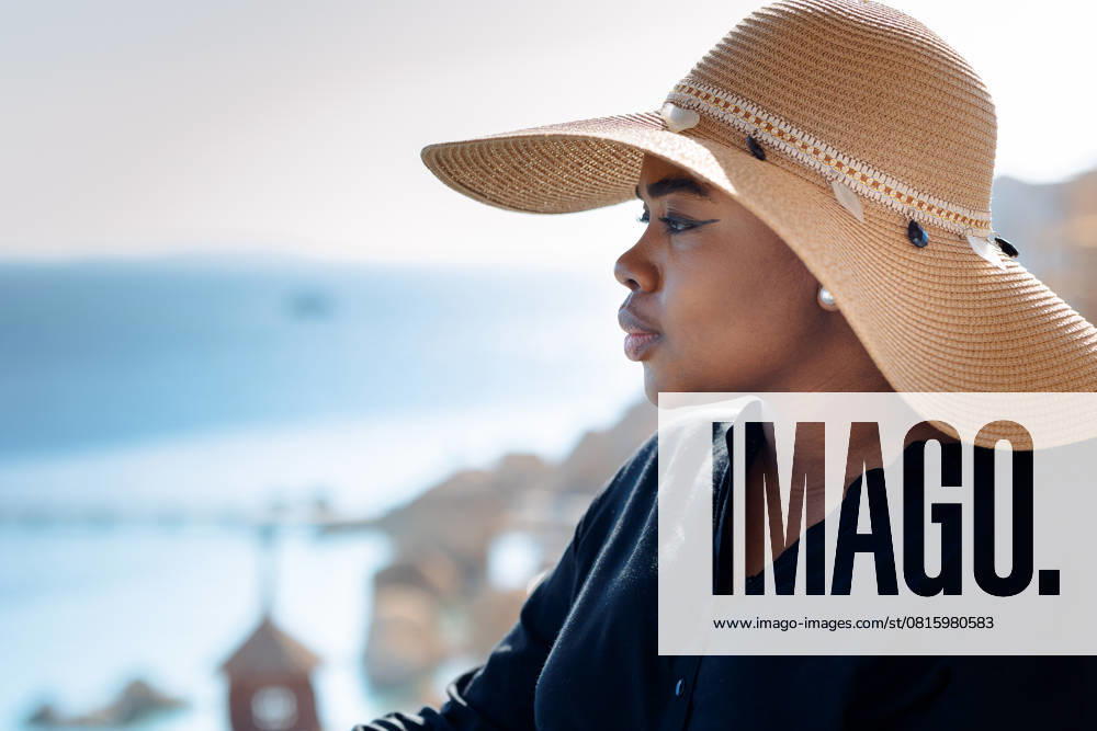 Porträt der schönen African American Model Mädchen in stilvollen Sonnenhut. Mode schwarze Frau auf natürlichen Hintergrund Küste des Meeres. Portrait of beautiful African American model girl in stylish sun hat. Fashion black woman on natural background coast of sea. High quality photo (License=RF) ,model released, Symbolfoto