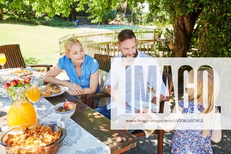 Girl serving plates for family at garden table model released Symbolfoto property released SRYF00619