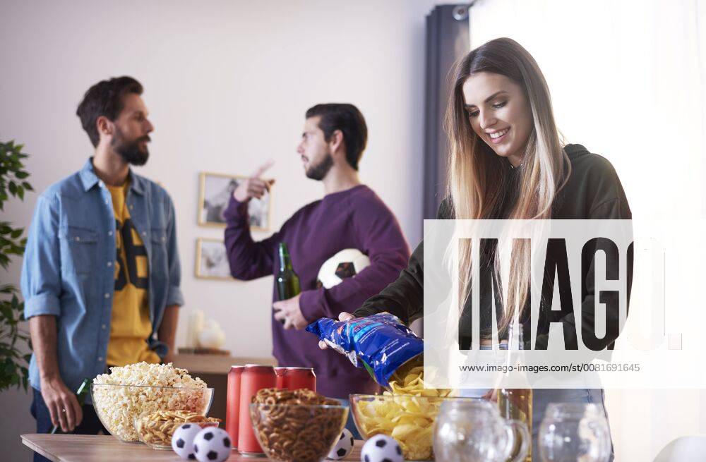 Friends preparing for football match with beer and snacks model released Symbolfoto property released ABIF00065