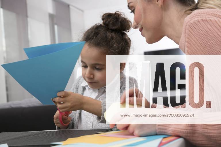 Mother and little daughter tinkering with colored fancy paper model released Symbolfoto GDF01191