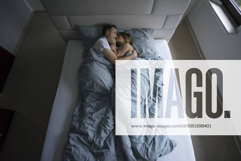 Top view of couple lying in bed at home kissing model released Symbolfoto property released MOEF00612