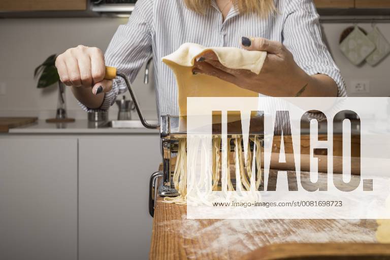 Woman preparing homemade pasta, using pasta maker model released Symbolfoto property released MAUF01260