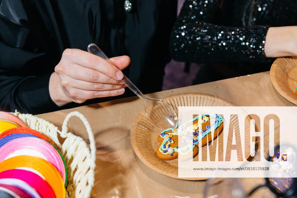 IMAGO Creative, Weihnachten, Food, Backen, Lebkuchen Verzieren eines Lebkuchenplätzchens mit Zuckerguss und Streuseln. Person using a spoon to decorate a gingerbread cookie with colorful icing and sprinkles during a festive holiday craft activity. (License=RF)