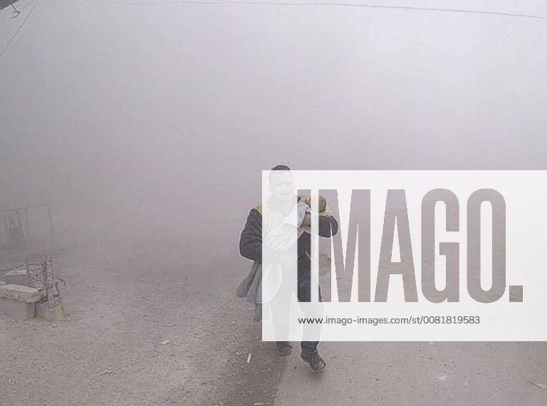 Feb 6, 2018 - Damascus, Syria - In a photo provided by the Syrian Civil Defense group, also known as the White Helmets, a paramedic carries his wounded son fleeing from the scene of an attack after airstrikes hit a rebel-held suburb near Damascus on Tuesday. Damascus Syria - ZUMA 20180206_jlr_z03_001