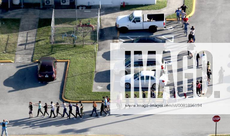 Parkland, FL, USA - Students are evacuated by police out of Marjorie Stoneman Douglas High School in Parkland after a shooter opened fire on the campus. , South Florida Sun-Sentinel Parkland USA - ZUMAss5_ 20180216_zaf_ss5_001