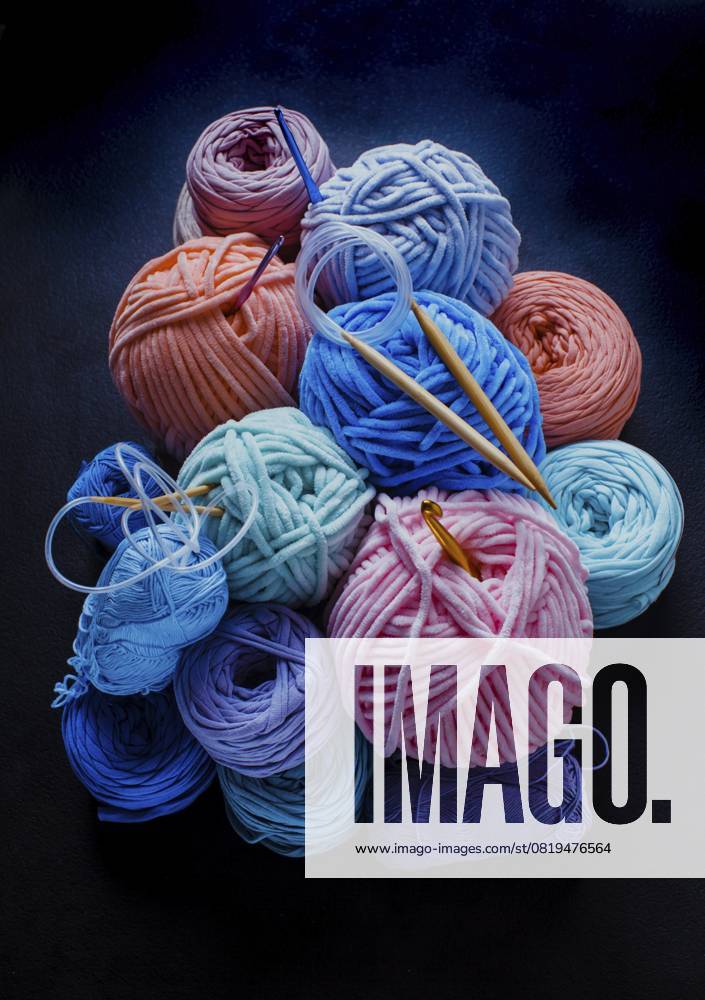 Haufen von Plüsch und Textilgarnkugeln mit Haken und Stricknadeln. Hobby Stillleben Heap of plush and textile yarn balls with hooks and knitting needles. Hobby still life