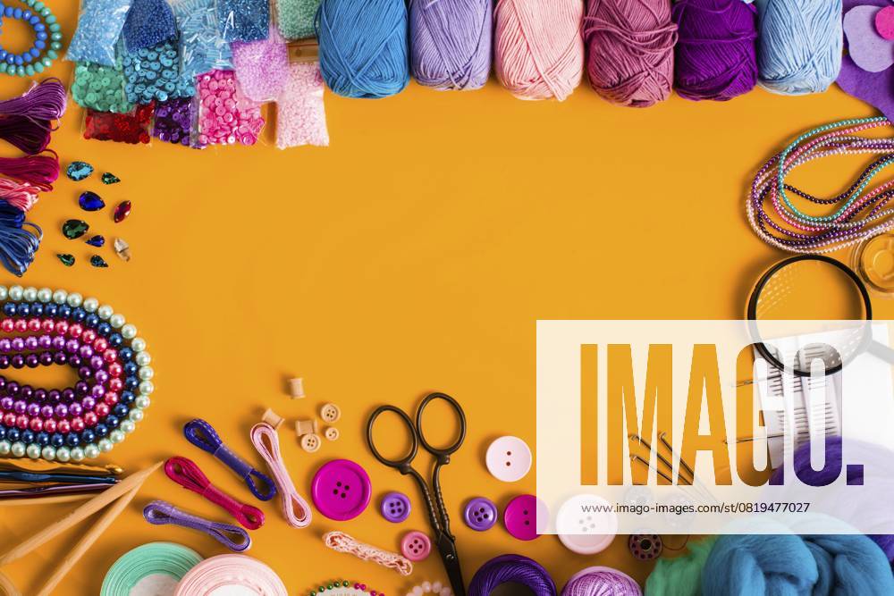 Bastelbedarf zum Stricken und kreatives Handarbeiten auf Gelb. Ansicht von oben, Platz für Text. Organisieren von DIY Elementen, Randgestaltung Craft supplies for knitting and creative handmade on yellow. Top view, place for text. Organizing DIY elements, border design