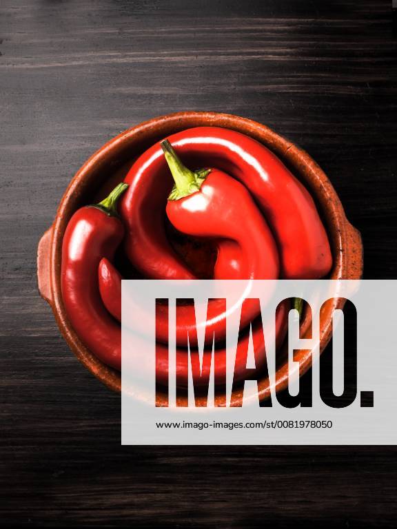 3. bent bell peppers in a bowl 3 crooked peppers bell peppers in a bowl on dark background 1028900627
